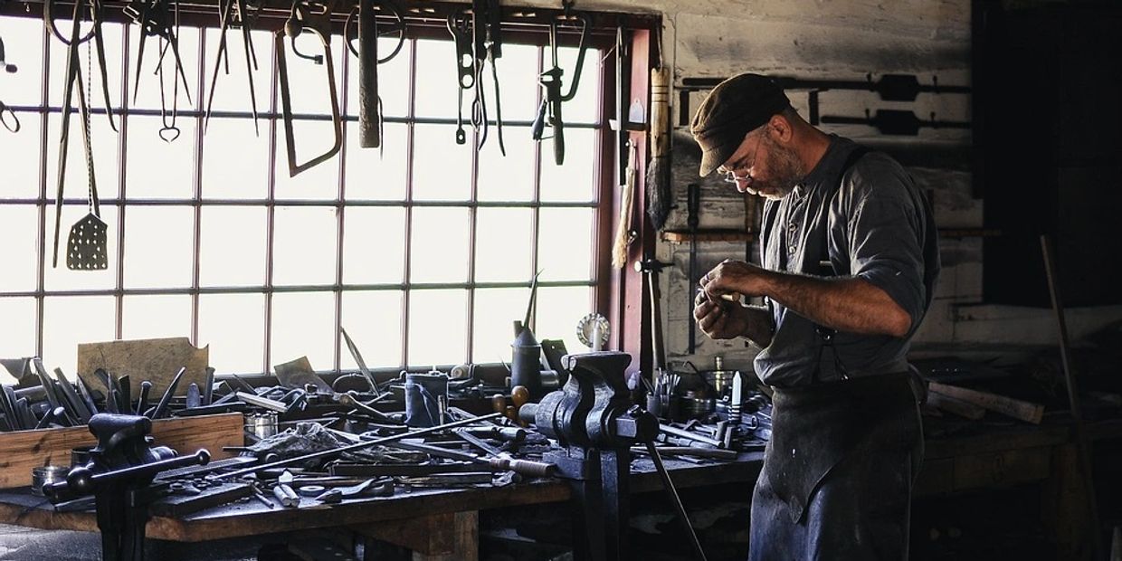 Master craftsman in shop with many tools about