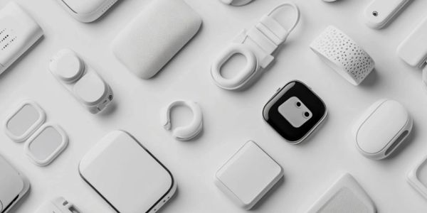 Flat lay of various white tech gadgets and accessories arranged neatly on a white surface.