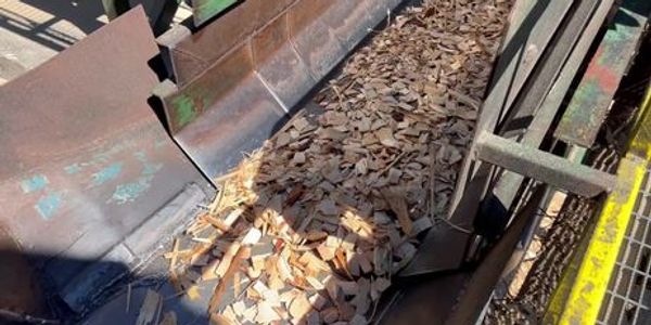 The shaker conveyor on the chipper line is moving wood chips while sorting smaller pieces and sawdus