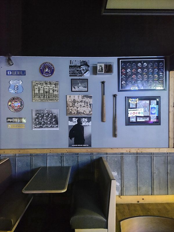 Sports memorabilia and vintage photos decorate a cozy booth seating area.