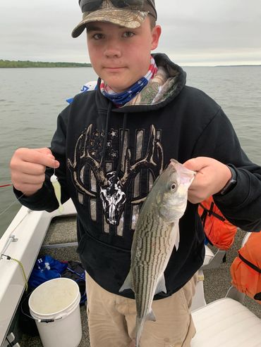 kid holding a striper