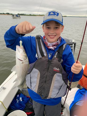 kid holding a striper