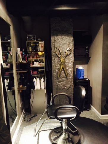 Our salon, showing my salon chair and product on the wall along with my golden scissors on the wall.