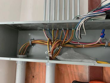 Organized multicolored electrical wires inside a metal junction box.