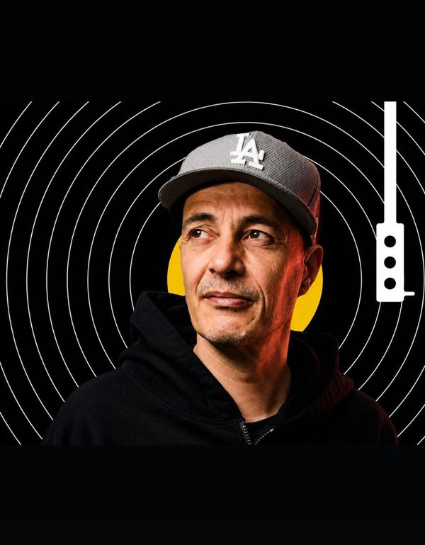 Man wearing LA cap with circular design background and turntable tonearm graphic.