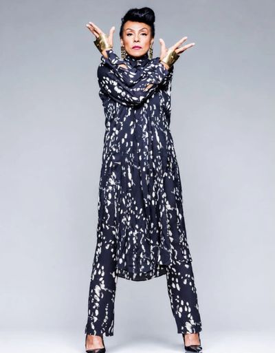 Woman in a black and white patterned outfit striking a confident pose.