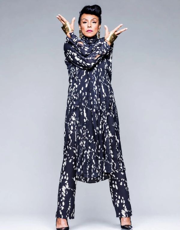 Woman in a black and white patterned outfit striking a confident pose.