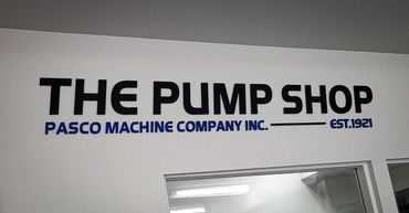 Black sign installation on white background that says "The Pump Shop"