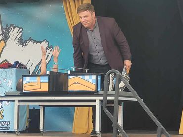 A lucky kid experiences the thrilling moment of being “sliced in half” during the show.