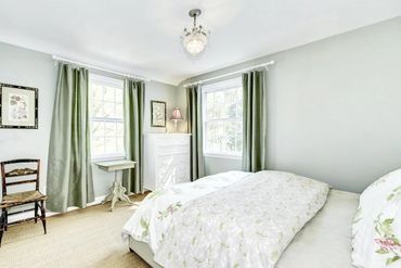 An example of Nest + Feather's home staging services showing a large, well styled bedroom