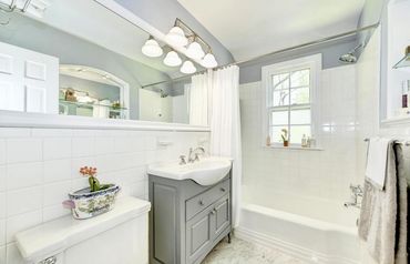 An example of Nest + Feather's professional home staging services featuring a grey & white bathroom