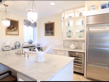 Nest + Feather design service renovated this now open kitchen which features a large marble island