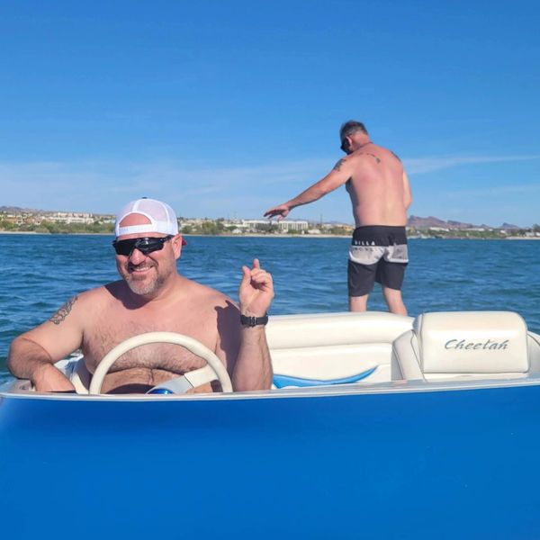 Two men enjoying a sunny day on a blue Cheetah boat.