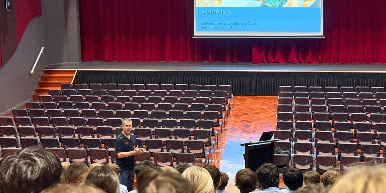 Man presenting to a mostly empty auditorium about gambling.
