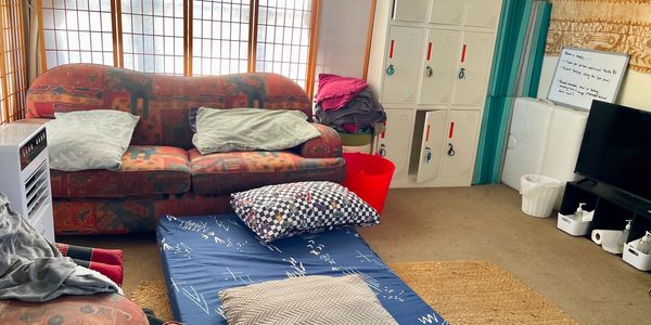Cozy living area with couch, mattress, and pillows.
