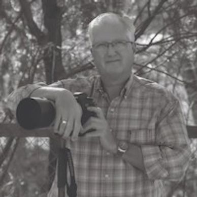 Man standing with camera on a tripod