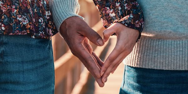 Couple holding their hands to form a heart pattern