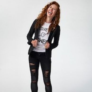 Woman laughing and smiling in front of a white background