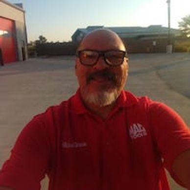 Man with sunglasses and red shirt smiling