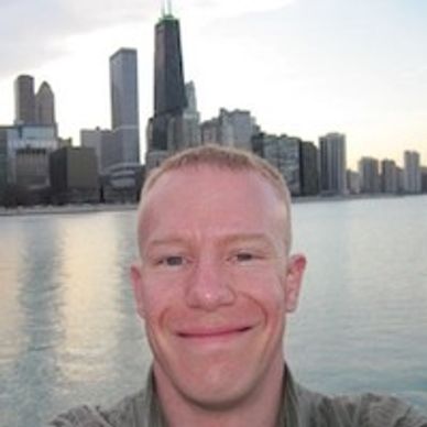 Man smiling with city buildings in the background