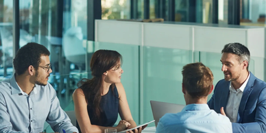 Four colleagues having a discussion in a modern office.