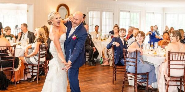 Bride and groom dancing joyfully at wedding reception.