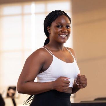 Smiling woman in workout attire at the gym.