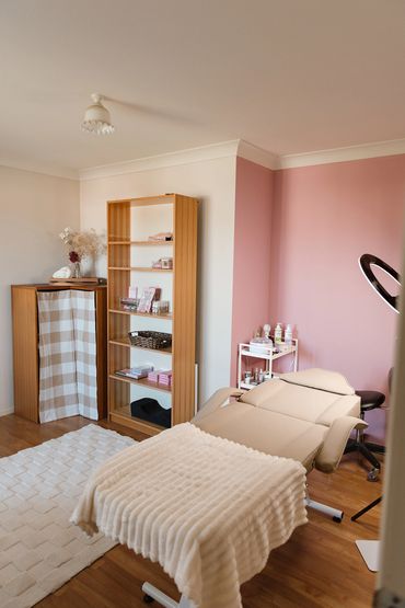 Cozy beauty treatment room with beige reclining chair and soft blanket.