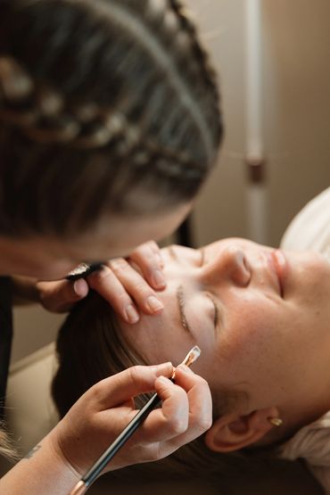 A person getting their eyebrows carefully groomed with a brush.