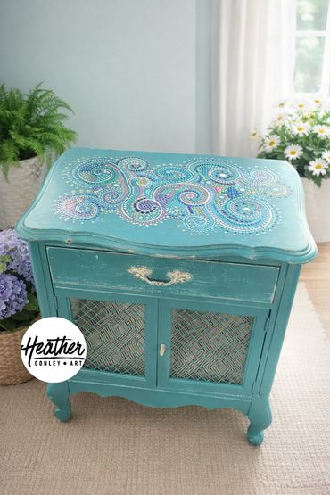 Hand-painted swirls and dots create this beautiful teal cabinet by Heather Conley
