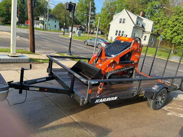A skid steer on a trailer.