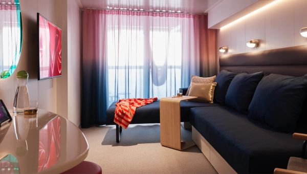 Modern living room with navy sofa, wooden table, and sheer ombre curtains.