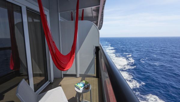Cozy balcony with a red hammock overlooking the ocean.