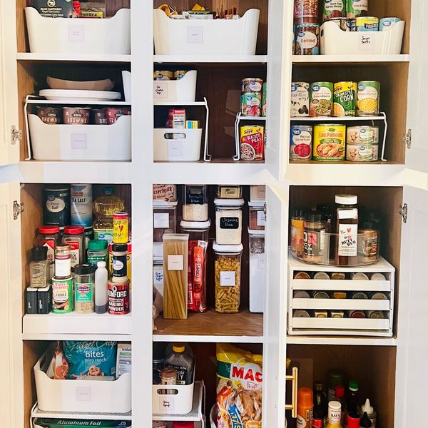 Organized kitchen pantry with labeled bins and neatly arranged food items.