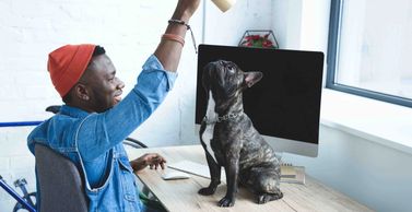 image of a man holding a cup above a dog's head