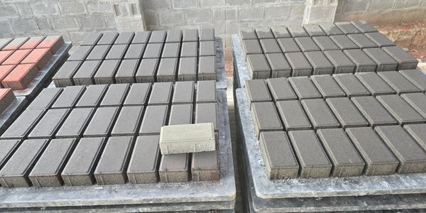 Stacks of gray rectangular concrete blocks neatly arranged on pallets.