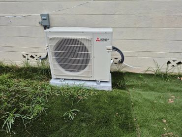 Outdoor Mitsubishi Electric multi zone heat pump unit on 4" pad.