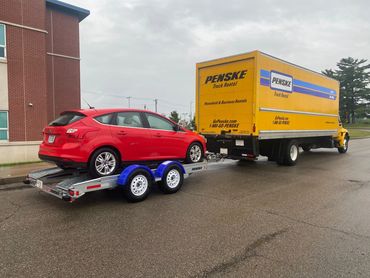 A truck hauling a red car
