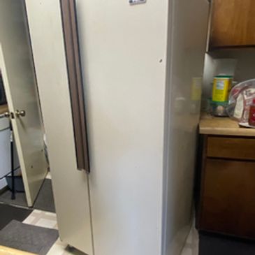 Old refrigerator in a kitchen ready for appliance removal and eco-friendly disposal service.