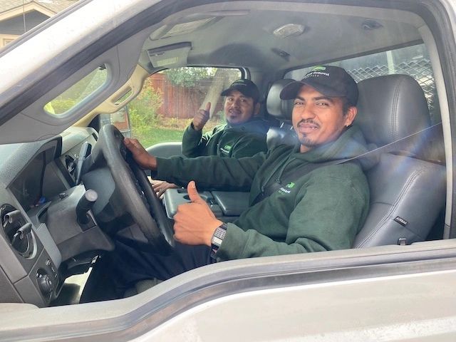 Professional junk removal specialist giving a thumbs up in a truck