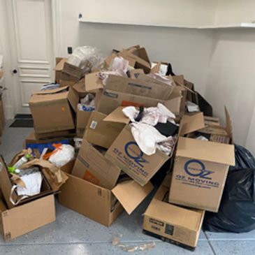 Multiple cardboard boxes filled with packing materials are staged for removal.