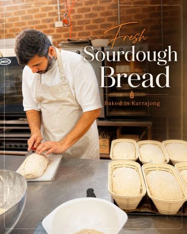 Baker slicing fresh sourdough bread in a rustic kitchen.