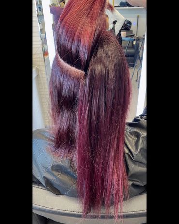 Hair transformation showing a vibrant reddish-purple color with a section lifted for styling.