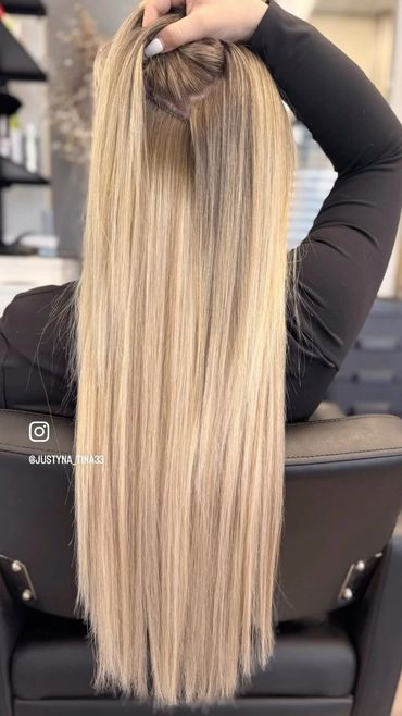 Long, straight blonde hair extensions being installed.