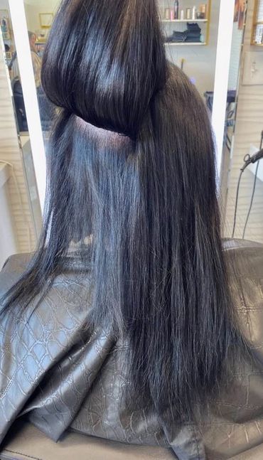 Long, straight, glossy black hair partially sectioned and lifted.