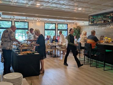 People dining and serving at a cozy restaurant.