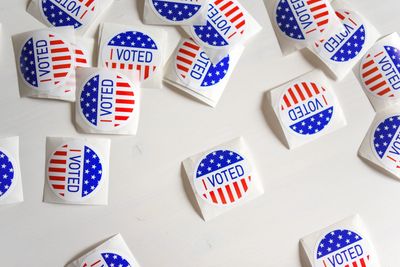 Many stickers saying "I Voted", scattered across a white surface.
