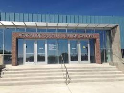 Entrance of Arapahoe County Justice Center with glass doors and steps.