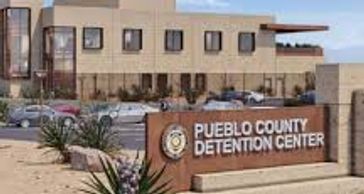Exterior view of Pueblo County Detention Center under a clear sky.
