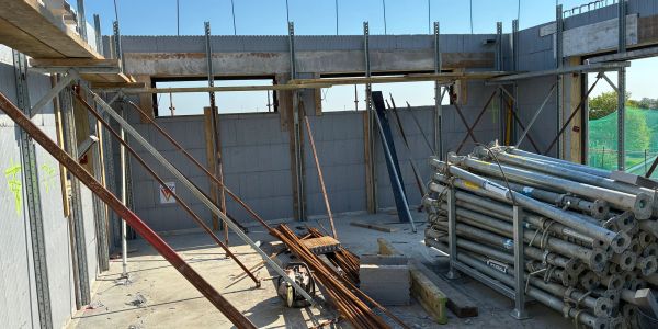 Construction site with concrete walls and scaffolding.